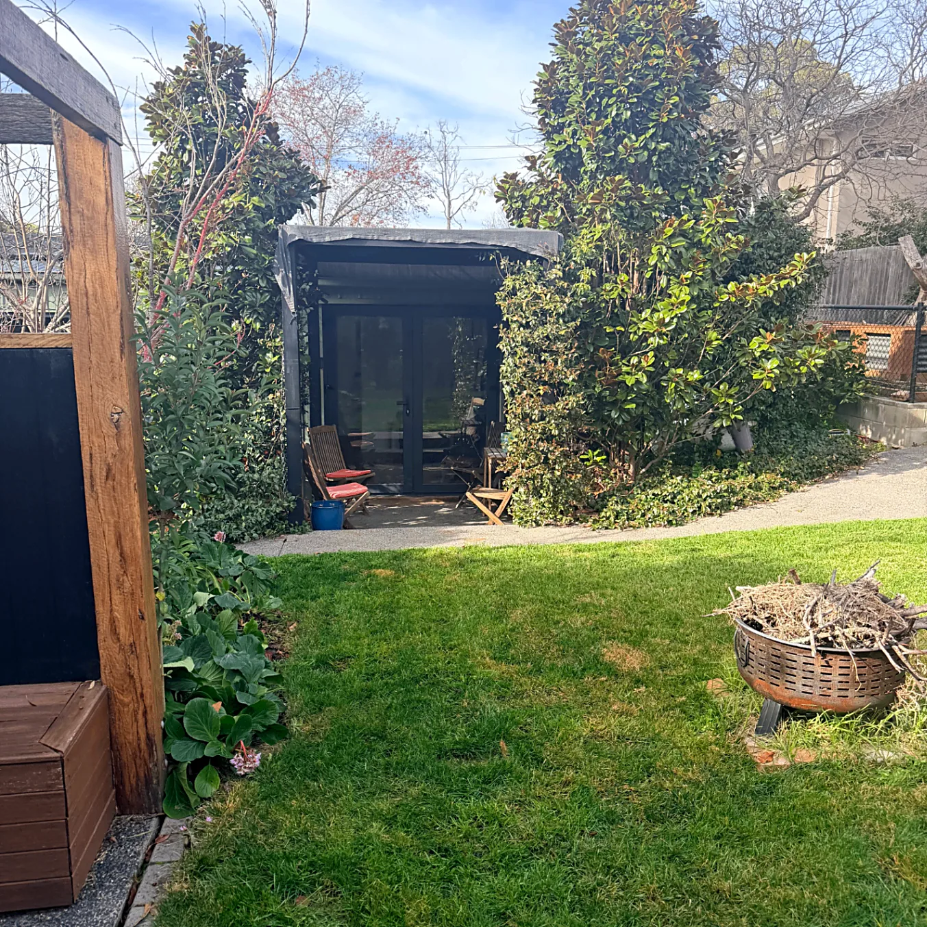 Studio courtyard with glass doors, chairs and lawn with fire pit