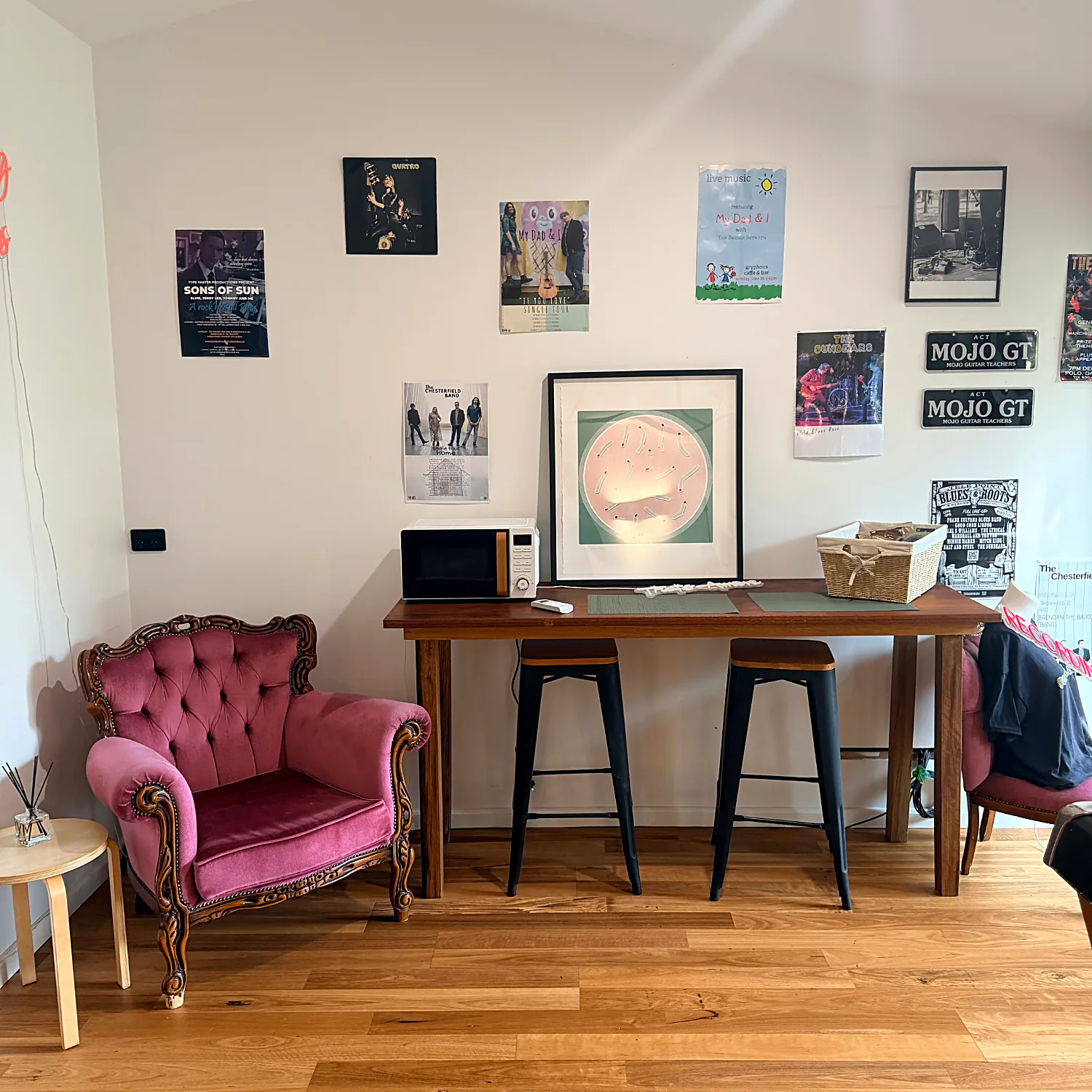 Studio lounge area with armchair, timber table and music posters