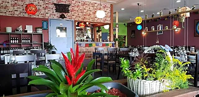 Inside Mustang Nepalese restaurant — brick feature wall, colourful hanging lanterns and a warm dining space
